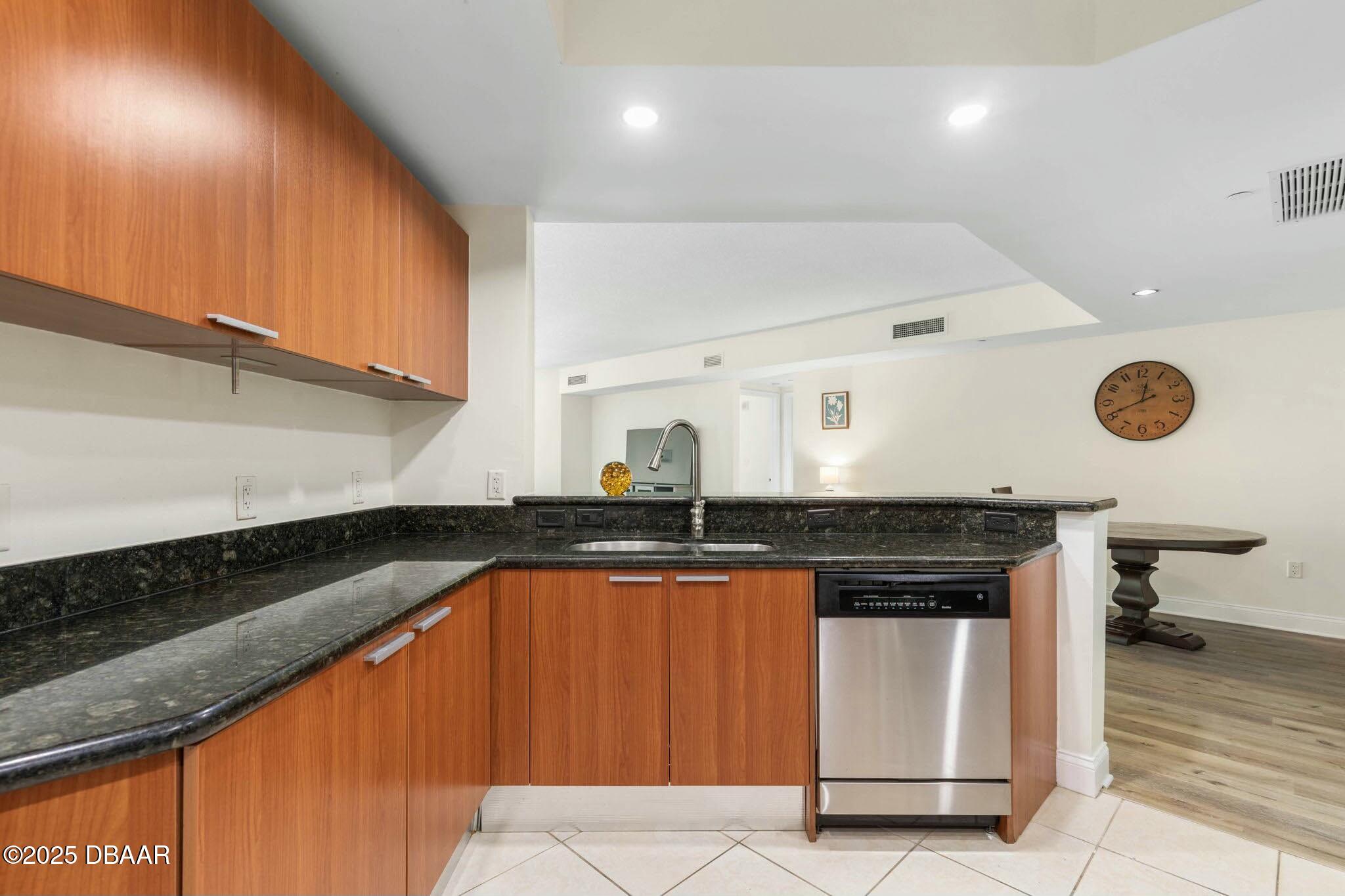231 Riverside Drive, Unit 1104 Holly Hill, FL 32117 - Photo 21 of 77 a kitchen with granite countertop a sink and a stove