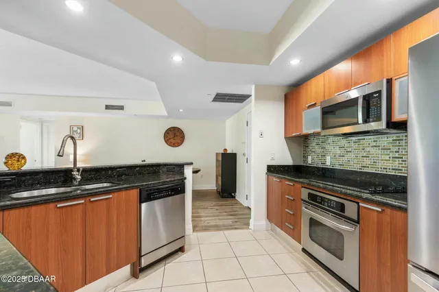 a bedroom with a bed a chandelier and a dresser