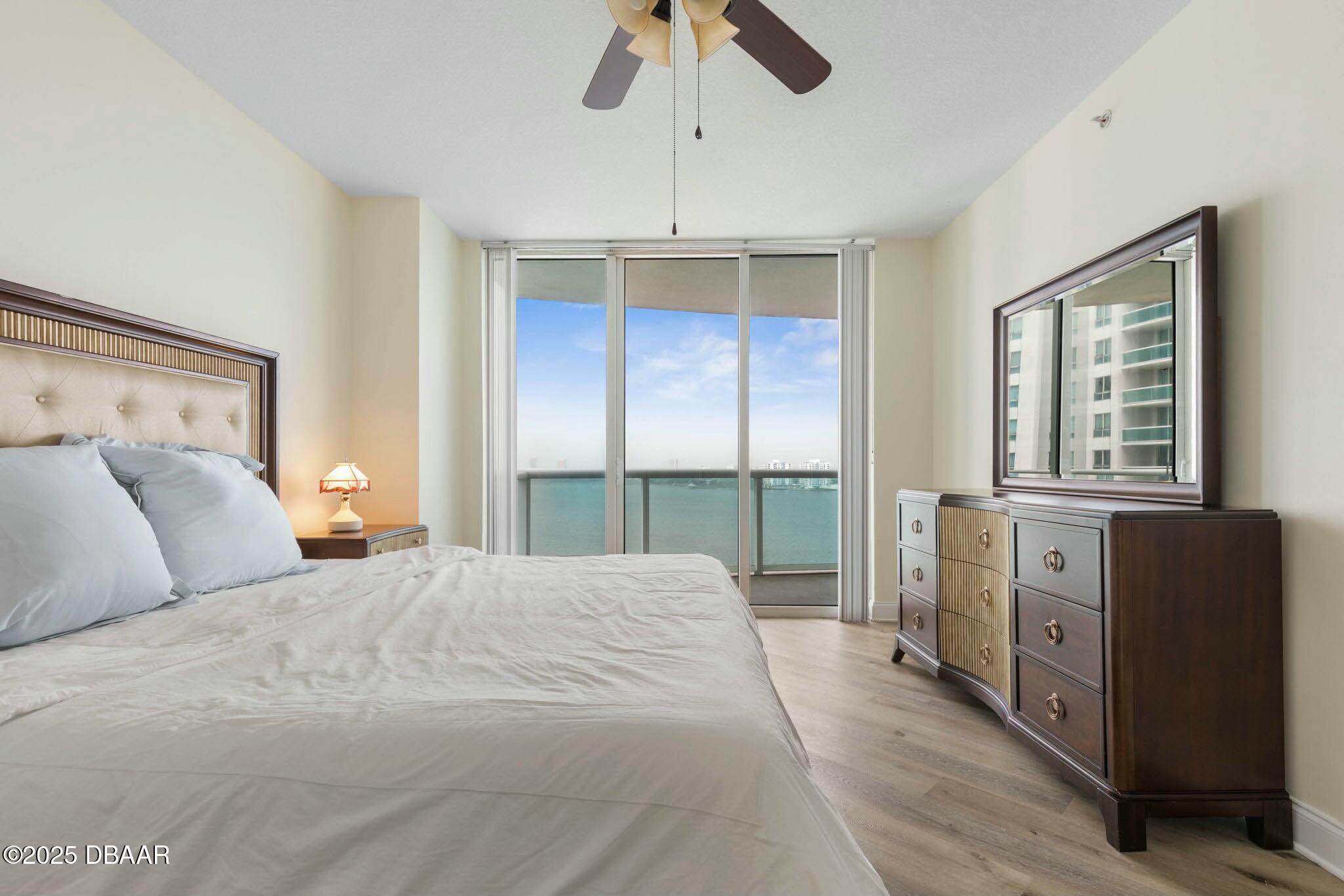 231 Riverside Drive, Unit 1104 Holly Hill, FL 32117 - Photo 32 of 77 a bedroom with a large bed and a chandelier fan