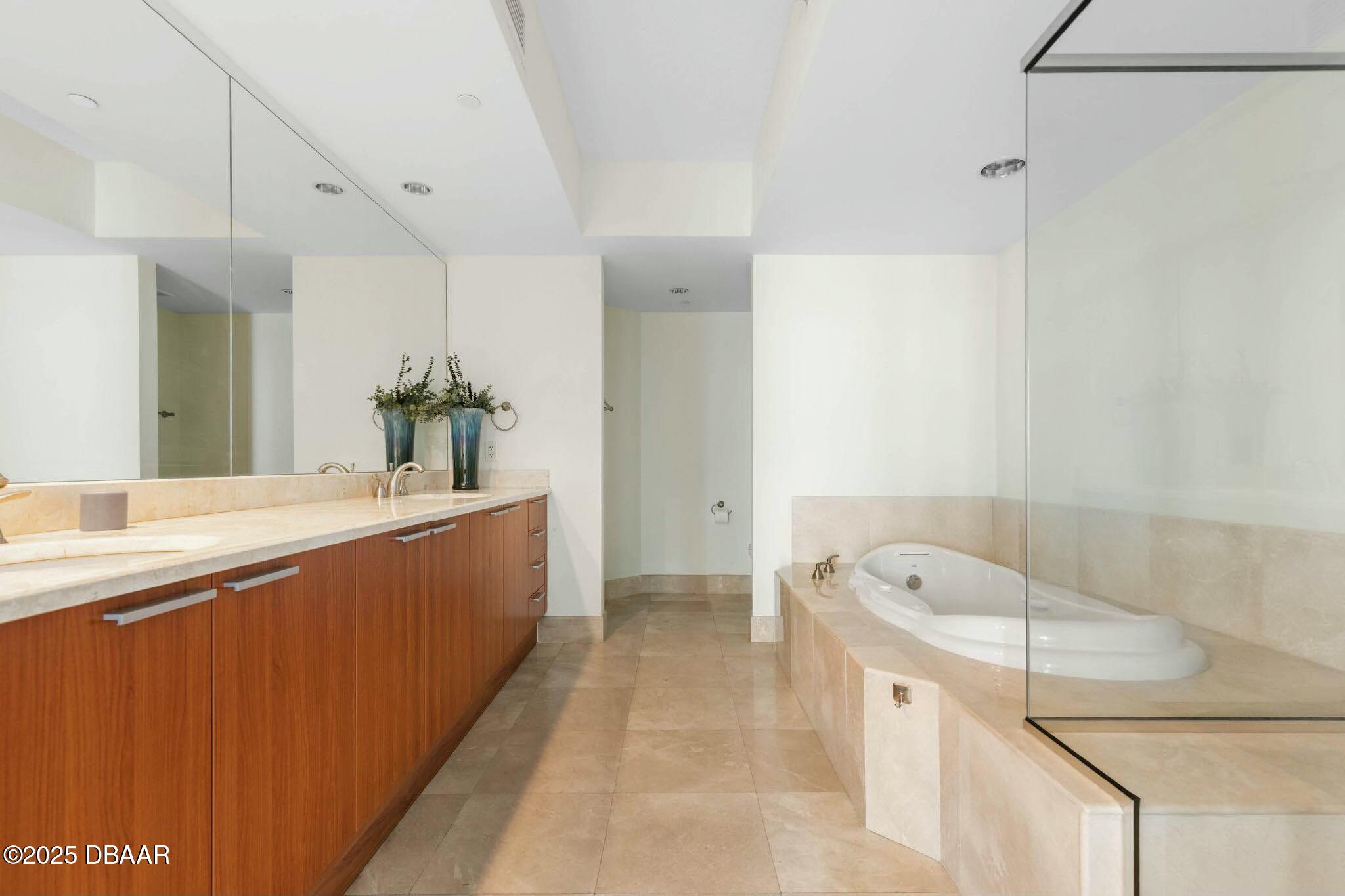 231 Riverside Drive, Unit 1104 Holly Hill, FL 32117 - Photo 34 of 77 a bathroom with a tub sink and mirror