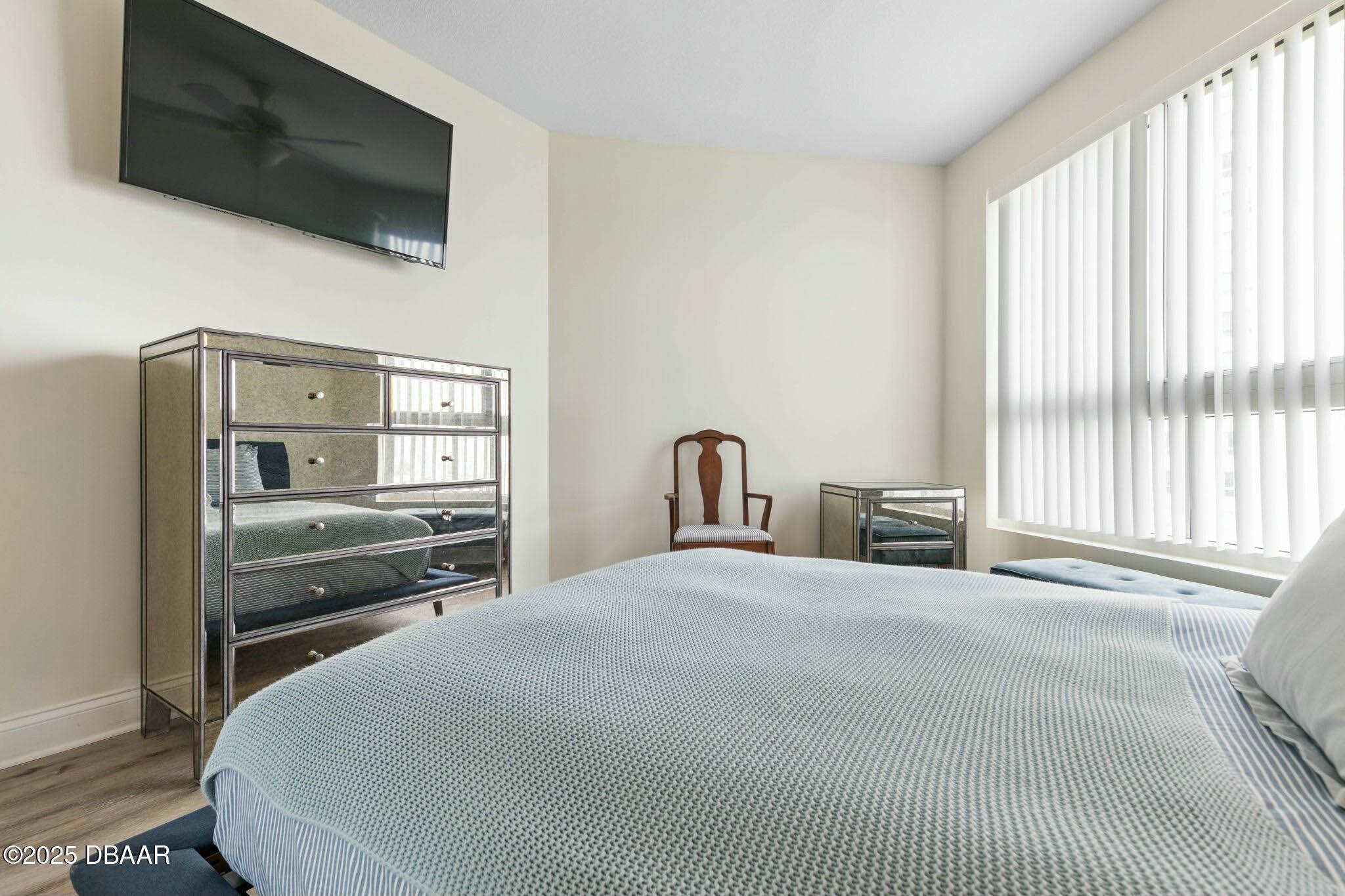 231 Riverside Drive, Unit 1104 Holly Hill, FL 32117 - Photo 40 of 77 a bedroom with a bed a television and a large window