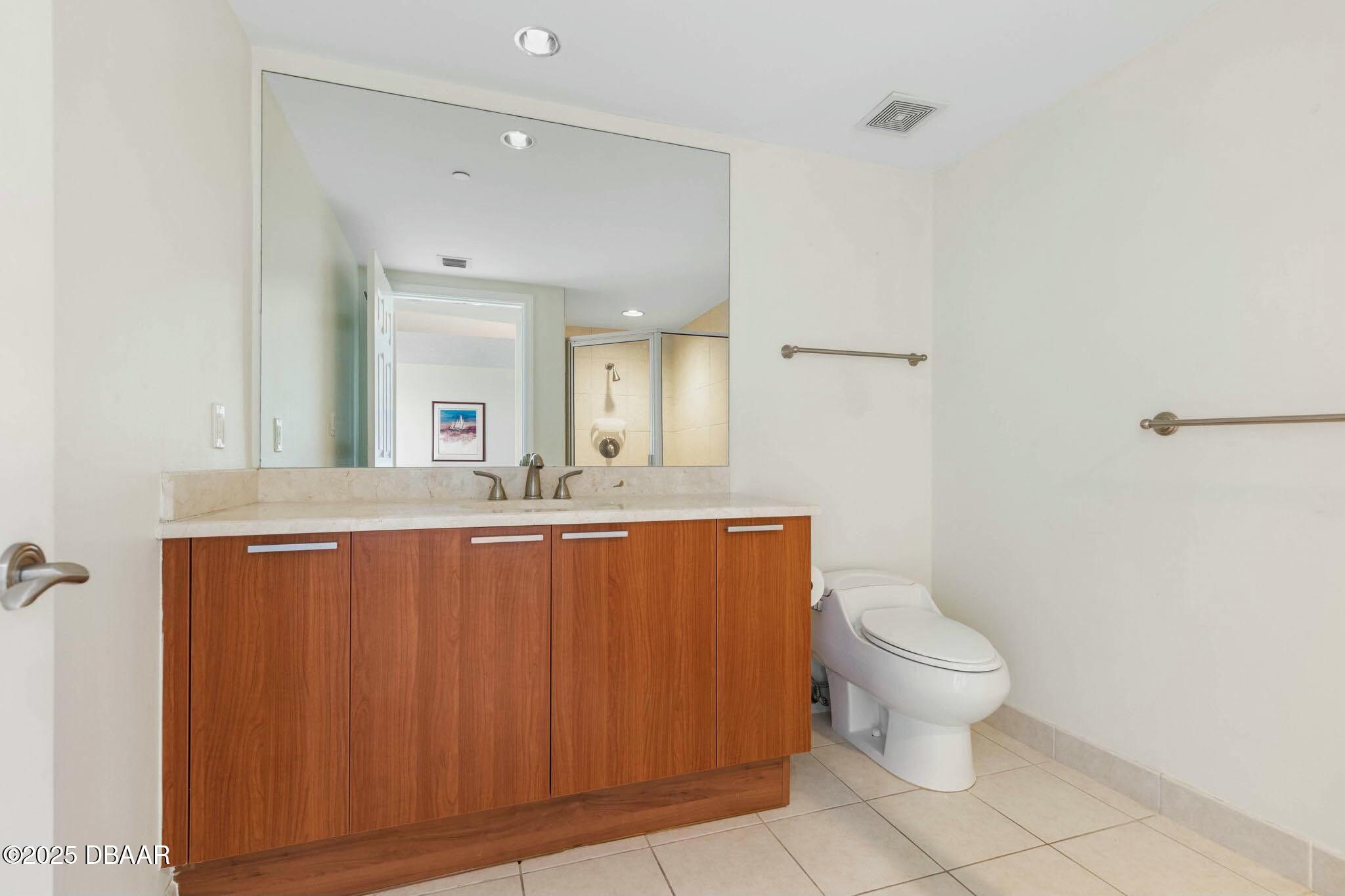 231 Riverside Drive, Unit 1104 Holly Hill, FL 32117 - Photo 41 of 77 a bathroom with a toilet a sink and mirror