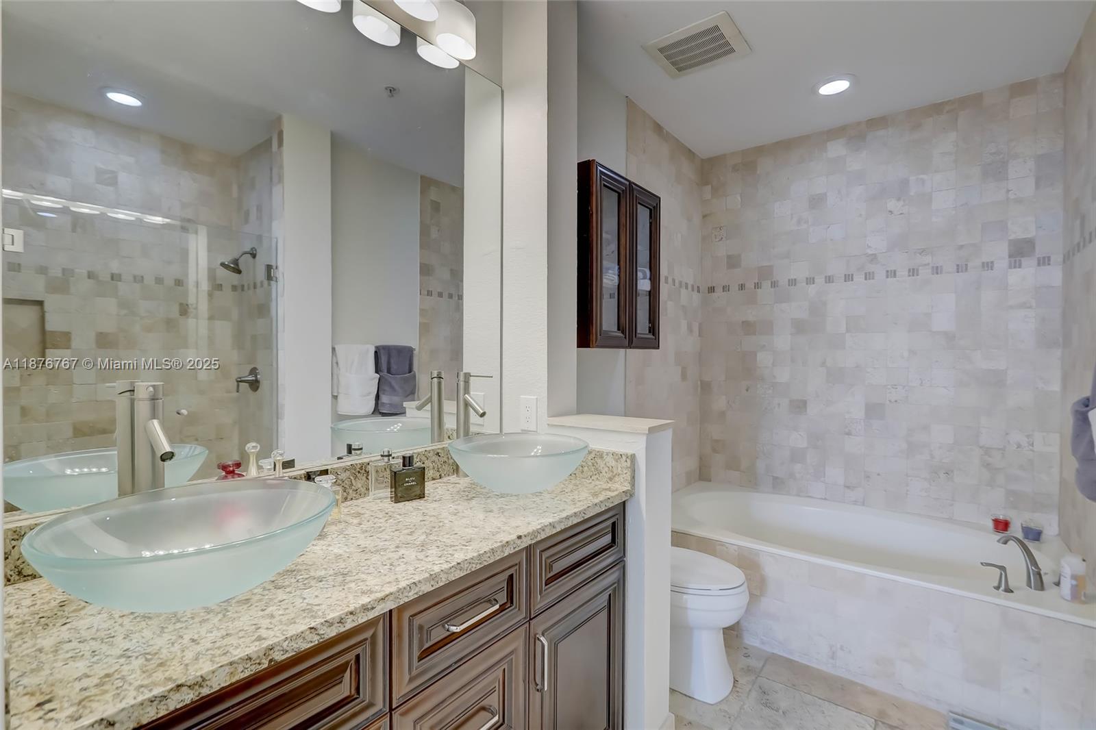 2039 Oceanwalk Lane, Unit 401 Pompano Beach, FL 33062 - Photo 12 of 12 a bathroom with a granite countertop sink a toilet and bathtub