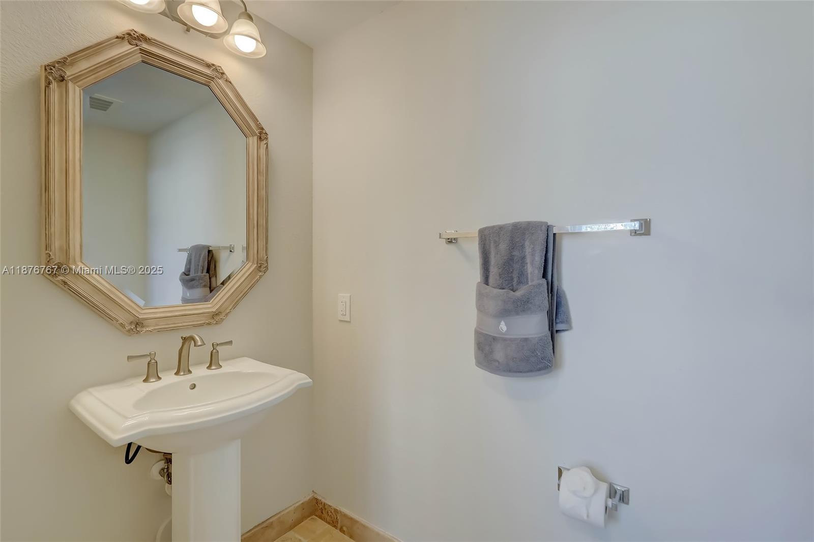 2039 Oceanwalk Lane, Unit 401 Pompano Beach, FL 33062 - Photo 10 of 12 a bathroom with a sink a mirror and vanity