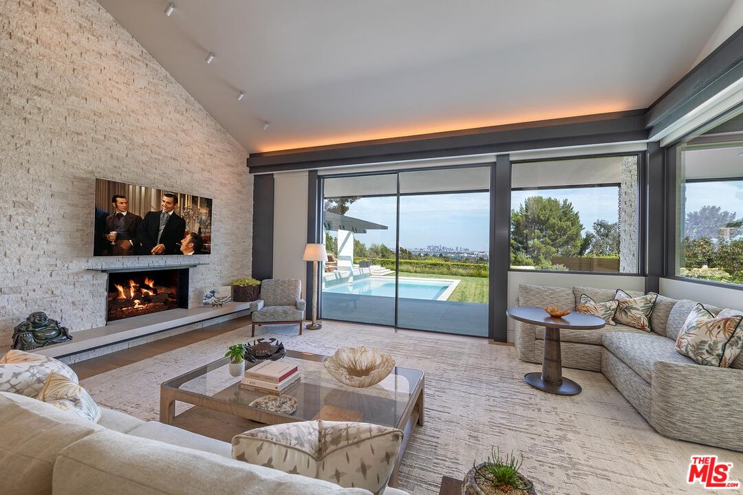 984 North Alpine Drive Beverly Hills, CA 90210 - Photo 16 of 25 a living room with furniture and a flat screen tv