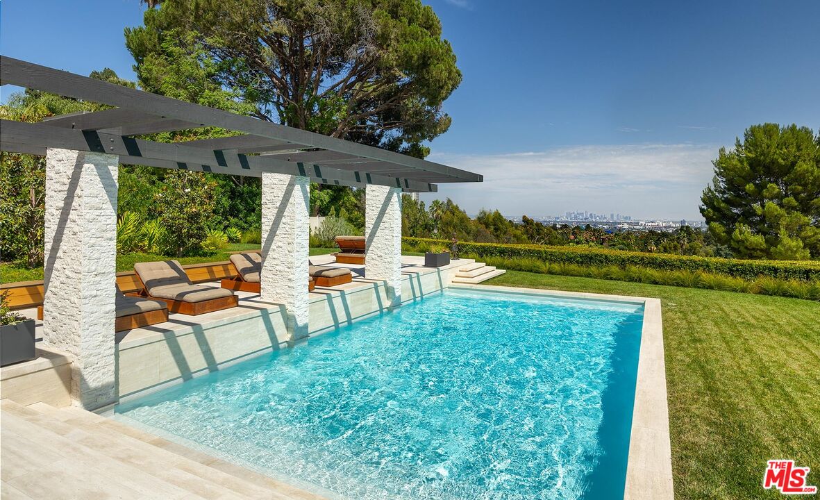 984 North Alpine Drive Beverly Hills, CA 90210 - Photo 25 of 25 a view of a swimming pool with lawn chairs under an umbrella