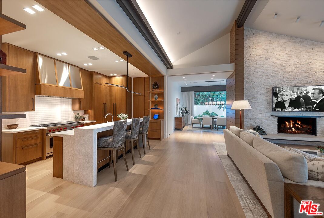 984 North Alpine Drive Beverly Hills, CA 90210 - Photo 6 of 25 a large white kitchen with lots of counter top space and stainless steel appliances