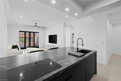 a kitchen with granite countertop a sink and a stove top oven with wooden floor