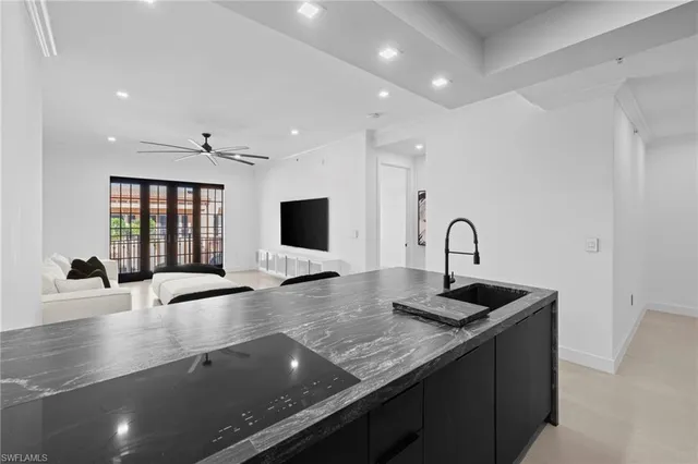 a kitchen with granite countertop a sink and a stove top oven with wooden floor