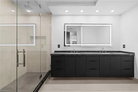 a bathroom with a granite countertop sink a mirror and shower