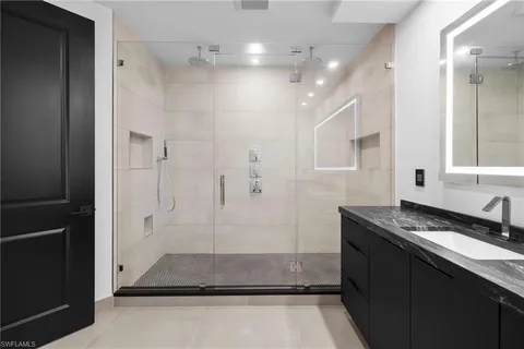 a bathroom with a granite countertop sink a toilet a mirror and shower