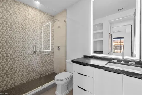 a bathroom with a granite countertop sink toilet and shower