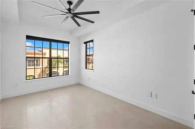 an empty room with a window and a fan