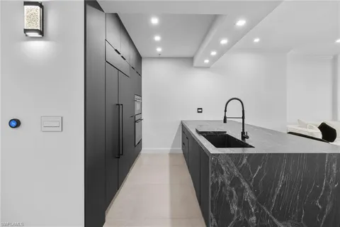 a kitchen with kitchen island a sink a refrigerator and a stove