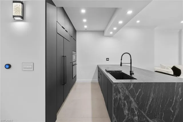 a kitchen with kitchen island a sink a refrigerator and a stove