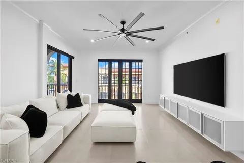 a living room with bed tv and a large window