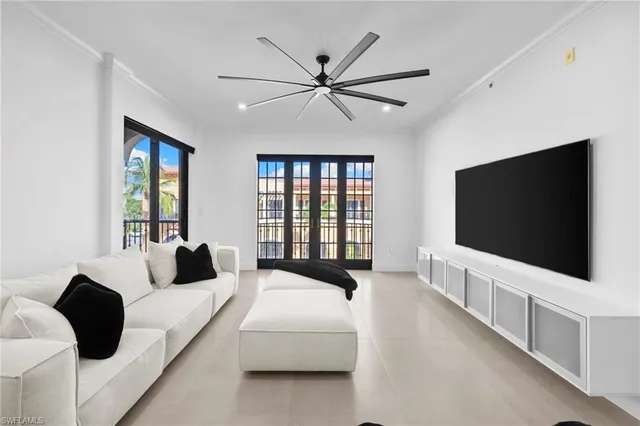 a living room with bed tv and a large window
