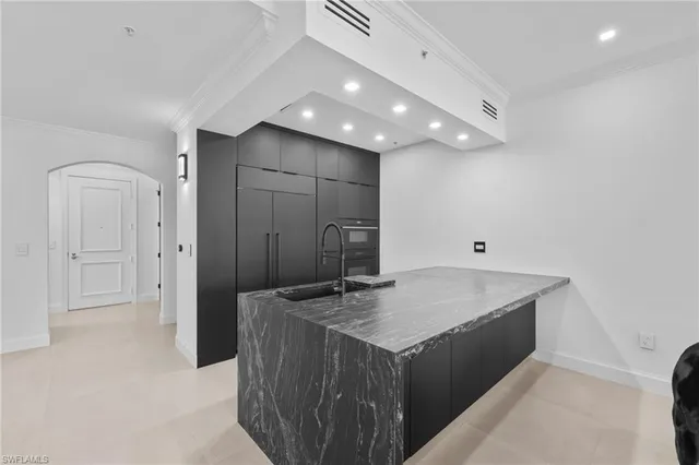 a bathroom with a granite countertop sink a refrigerator and a mirror