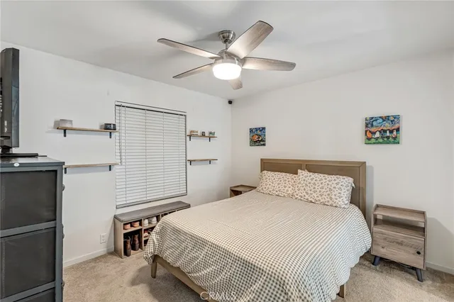 a bedroom with a bed and a ceiling fan