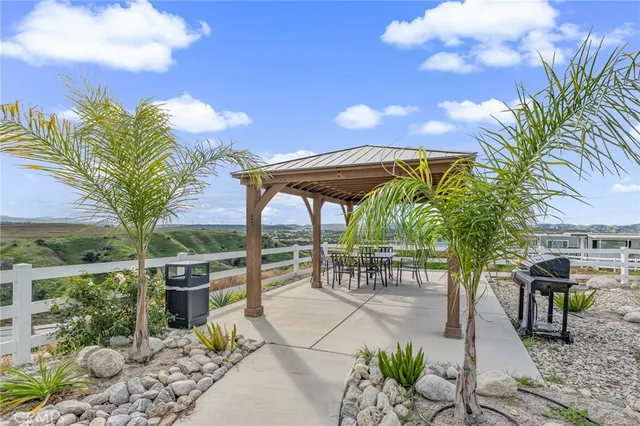 a patio with table and chairs and potted plants