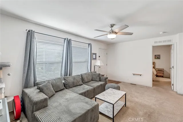 a living room with furniture and a ceiling fan