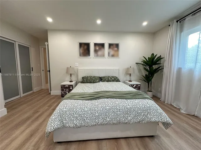 a bedroom with a large bed and a wooden floor