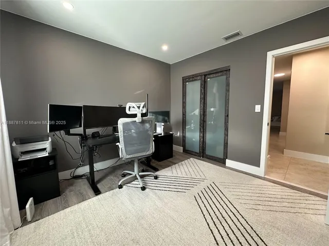 a bedroom with a bed and a flat tv screen on dresser