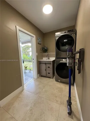 a living room with stainless steel appliances kitchen island granite countertop a refrigerator a sink dishwasher a dining table and chairs with wooden floor