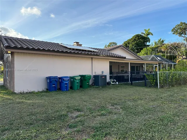 a view of a house with backyard and sitting area