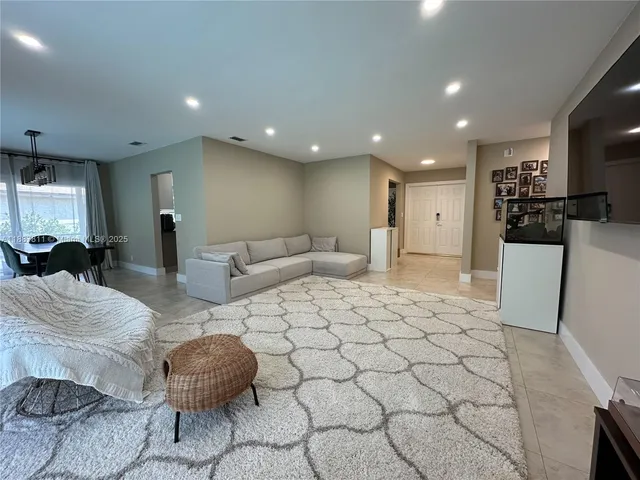 a large room with kitchen island granite countertop a sink and cabinets