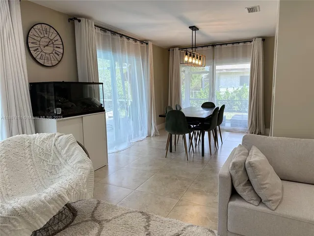 a dining room with furniture and a large window