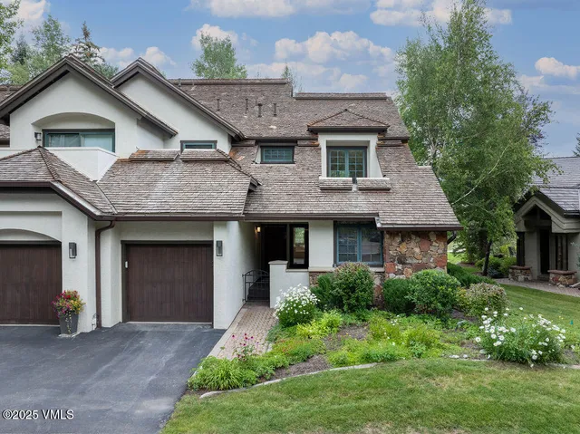 a front view of a house with a garden and plants