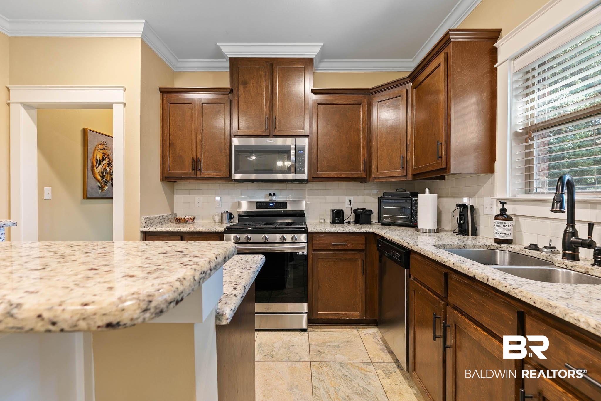 19740 Bunker Loop Fairhope, AL 36532 - Photo 13 of 33 Kitchen with decorative backsplash, appliances with stainless steel finishes, light stone counters, and crown molding