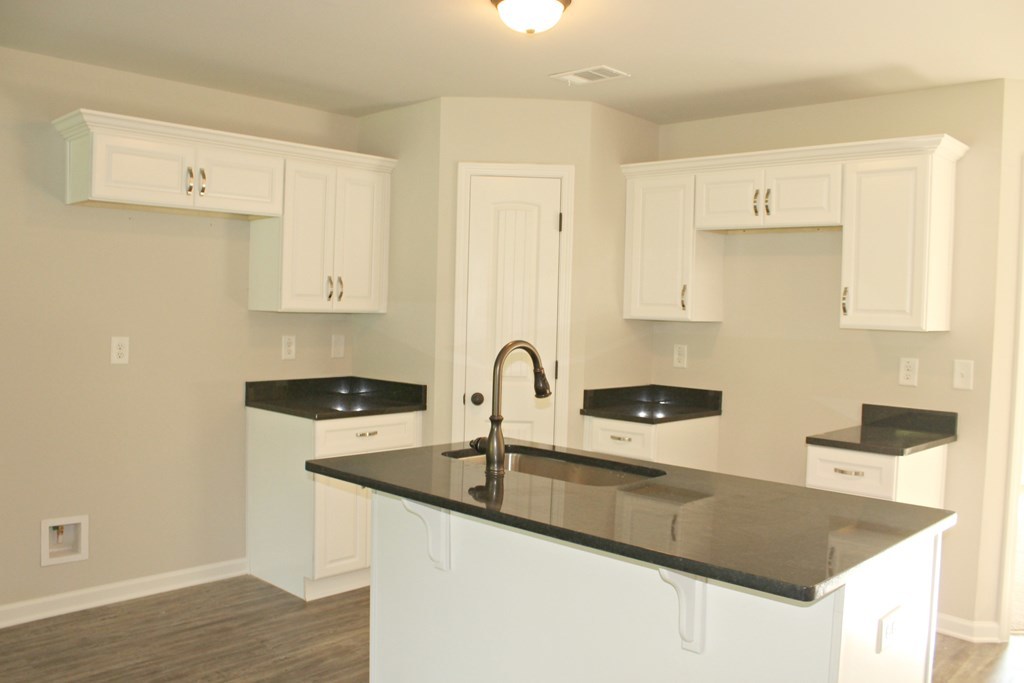 933 Weldon Road Forsyth, GA 31029 - Photo 3 of 7 a kitchen with granite countertop a sink a stove and cabinets