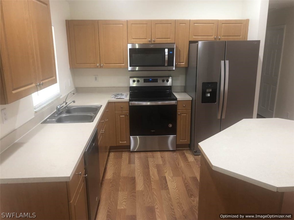 4652 27th Street Southwest Lehigh Acres, FL 33973 - Photo 7 of 21 a kitchen with a refrigerator and a sink