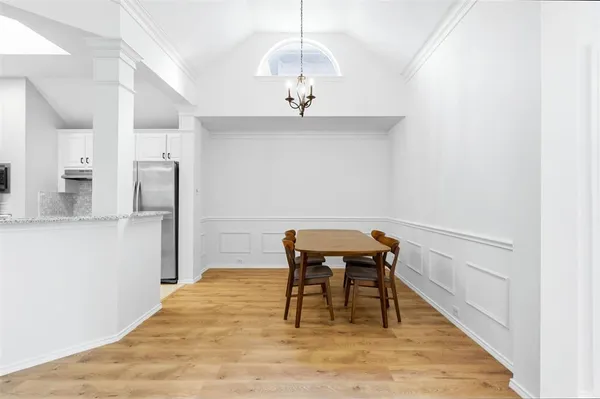 a hallway with a dining table and chandelier