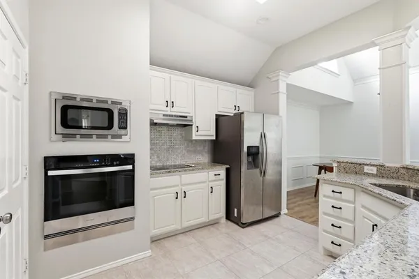 a kitchen with stainless steel appliances granite countertop a refrigerator and a sink