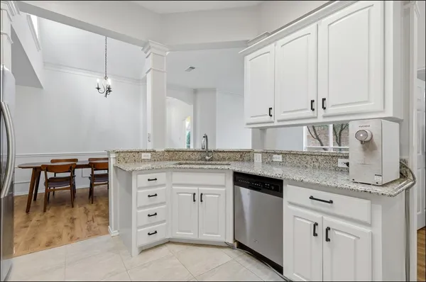 a kitchen with stainless steel appliances white cabinets and a refrigerator