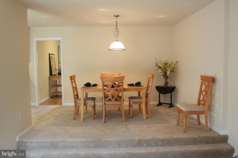 12005 Insha Court Reston, VA 20191 - Photo 8 of 22 a dining room with furniture a rug and a chandelier