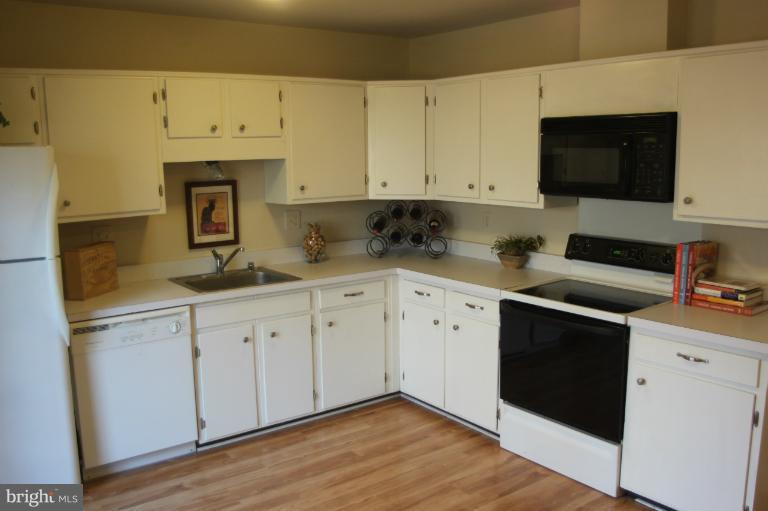 12005 Insha Court Reston, VA 20191 - Photo 9 of 22 a kitchen with granite countertop cabinets stainless steel appliances and wooden floor