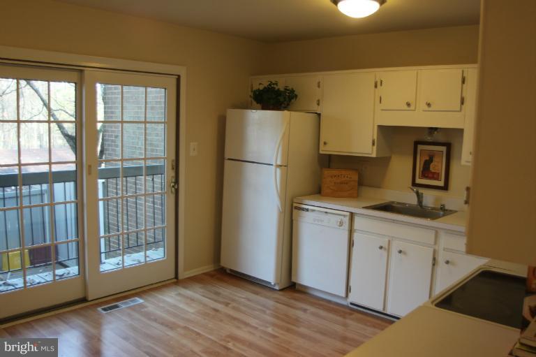 12005 Insha Court Reston, VA 20191 - Photo 10 of 22 a kitchen with a refrigerator a stove a microwave and wooden floor