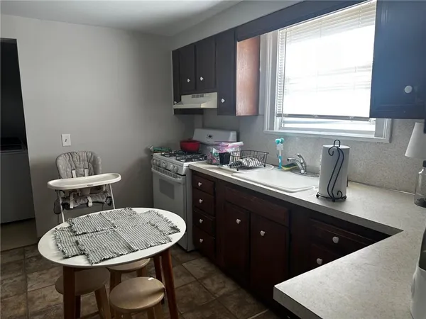 a kitchen with a sink a stove a table and chairs