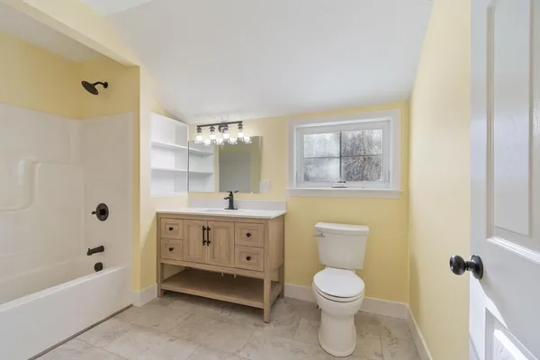 a bathroom with a toilet a sink a mirror a bathtub and shower