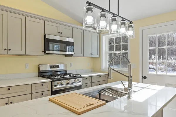 a kitchen with stainless steel appliances a stove sink and microwave