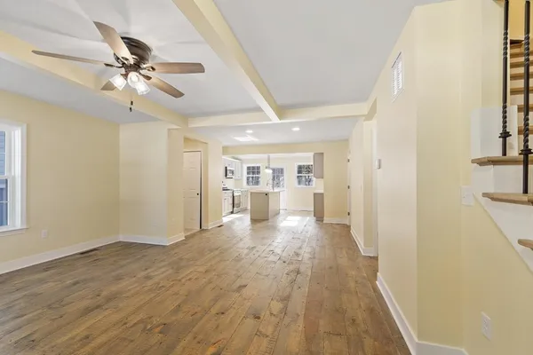 a view of a big room with wooden floor and a ceiling fan