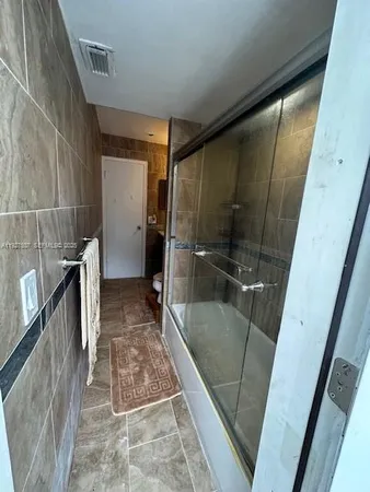 a bathroom with a glass door shower and a sink
