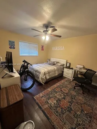 a bedroom with two beds and a ceiling fan