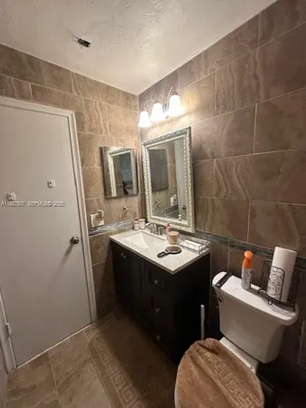 a bathroom with a sink toilet and mirror