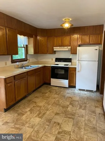 a kitchen with stainless steel appliances granite countertop a stove a sink dishwasher and a refrigerator
