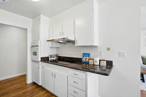 a kitchen with stainless steel appliances granite countertop white cabinets and a granite counter tops